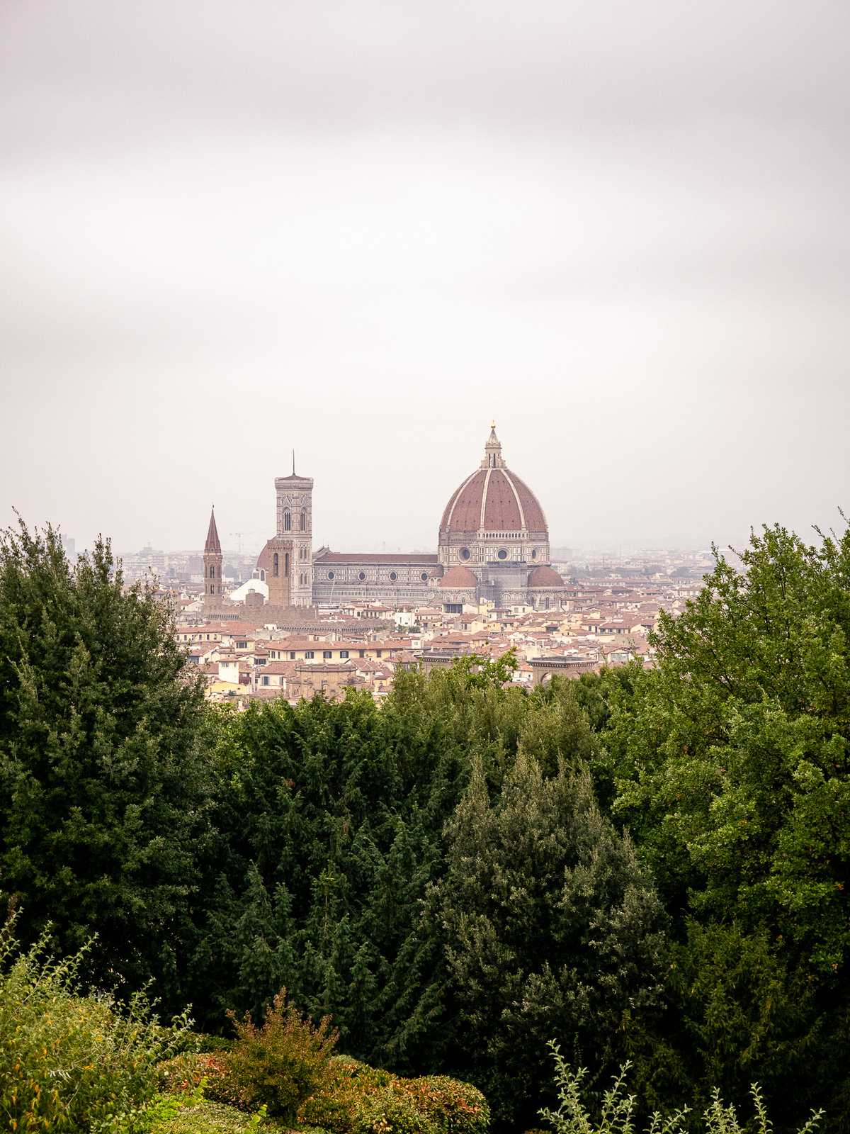 A large historic church stands above old city buildings in Florence