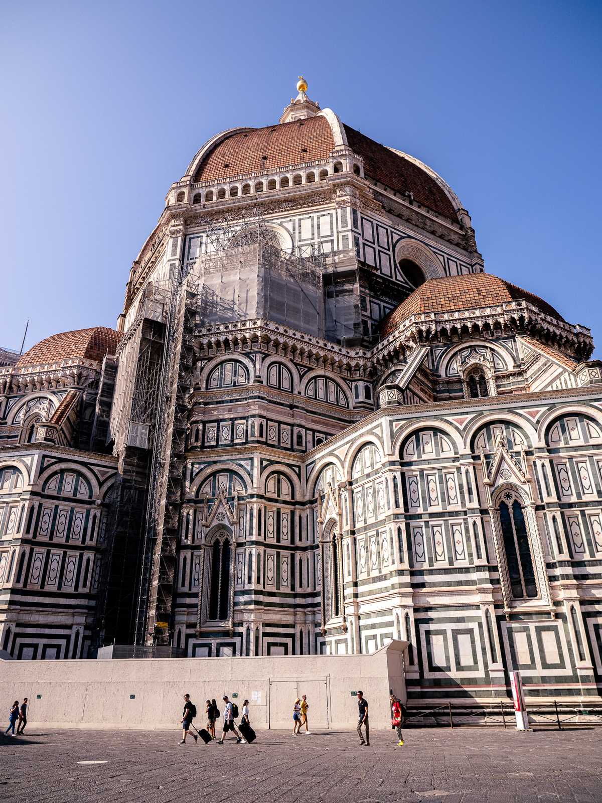 A large church towers over tourists, with a golden globe on top