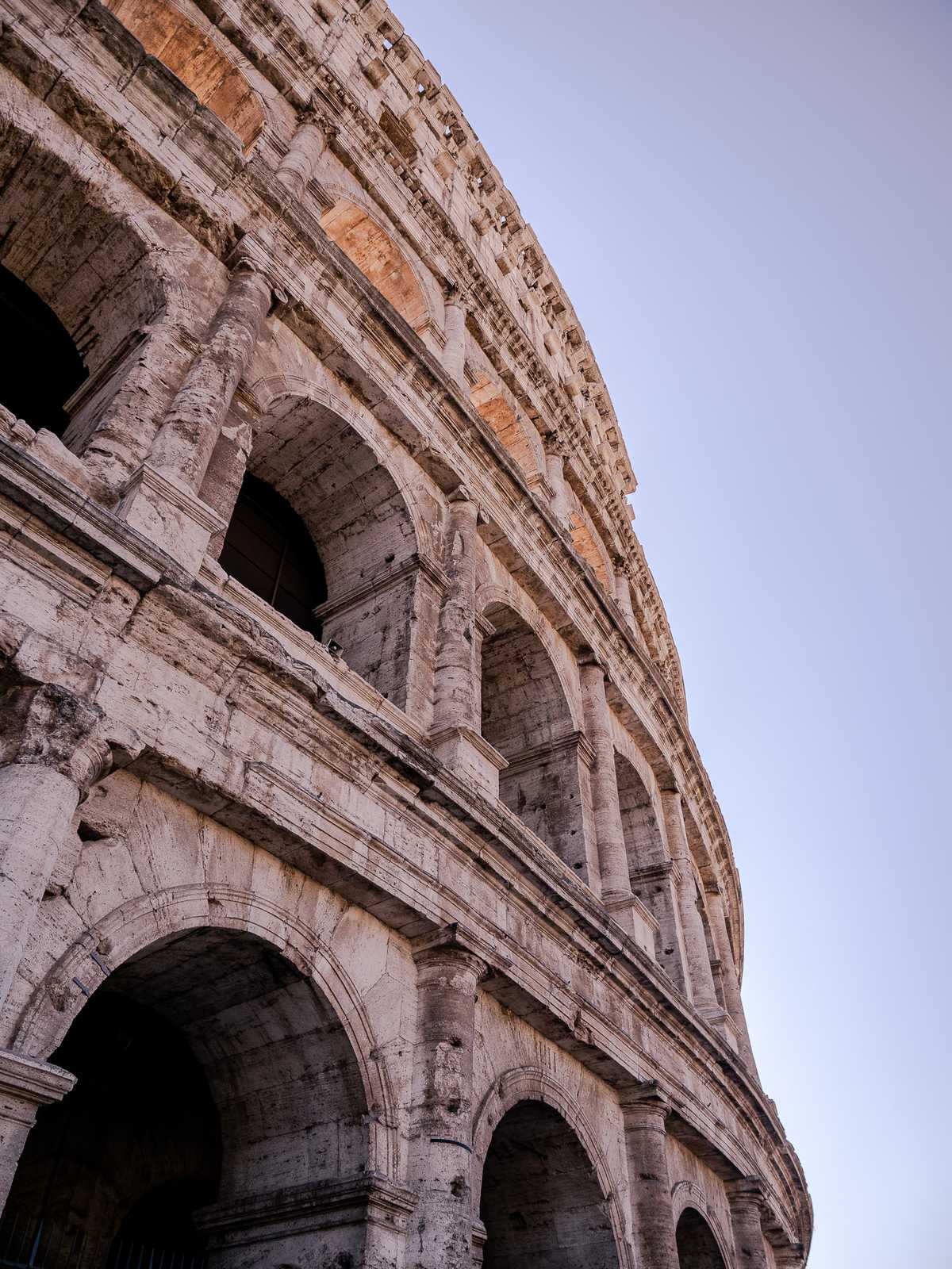 Looks upward at a wall of the Rome coliseum 