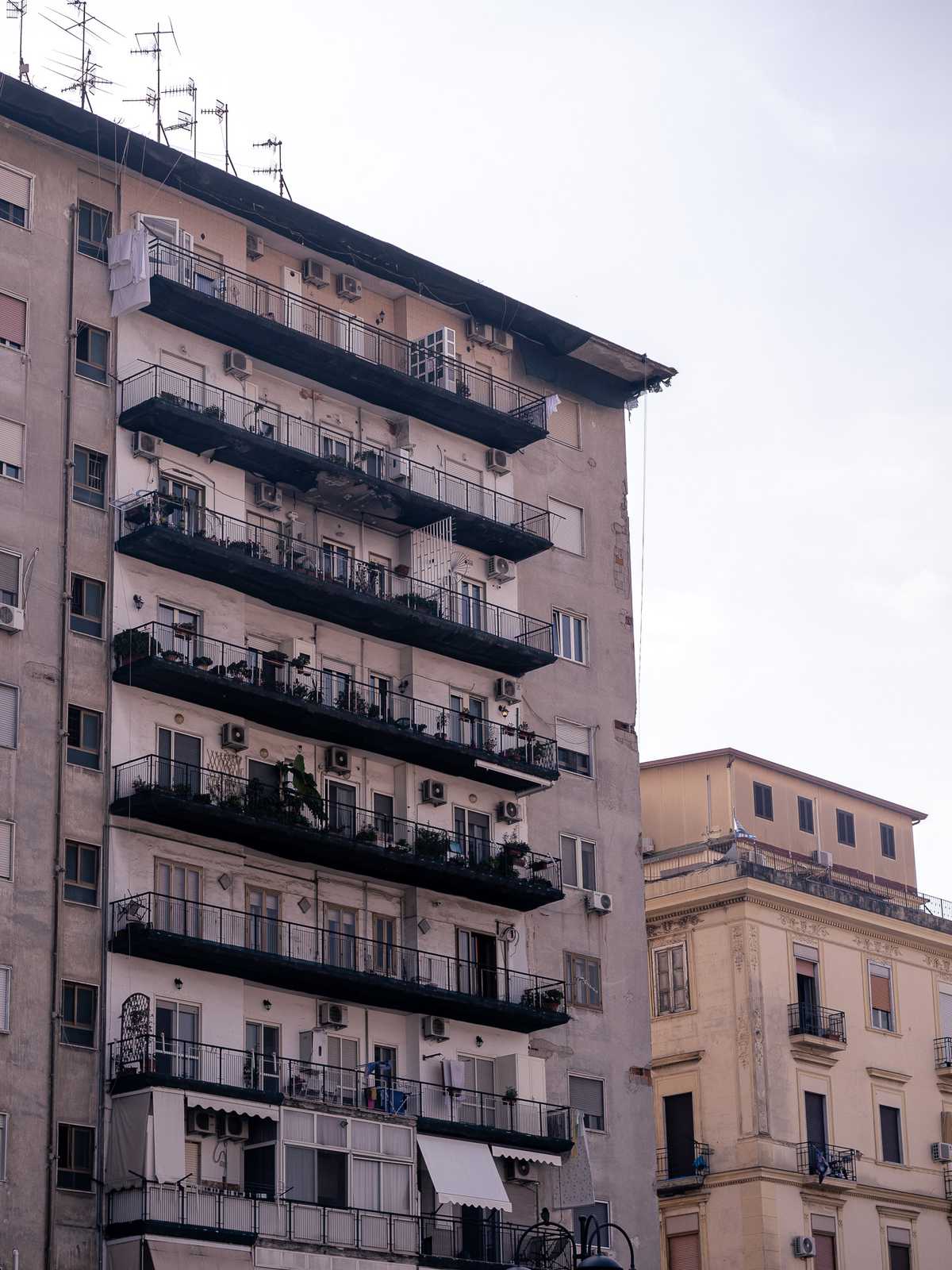 An apartment building in Naples, Italy, with patios and stucco 