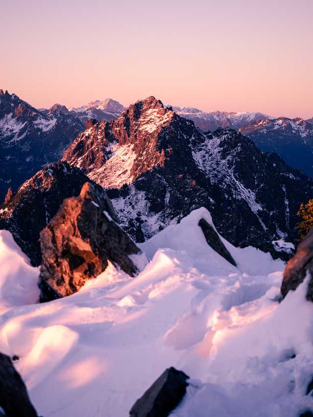 Mountain Peak lit and shaded in the glows of a purple and pink Sunset.