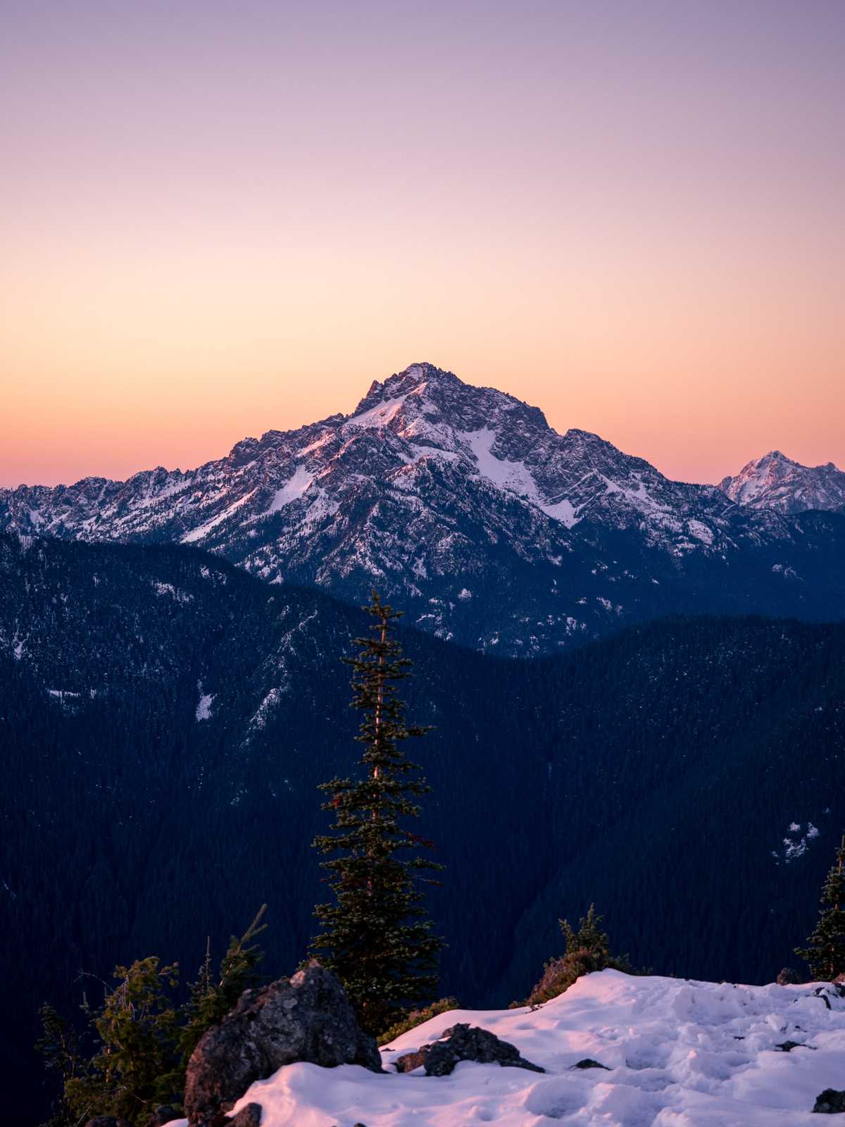 Mountain rises into the sunrise, reflecting the colors of pink and orange