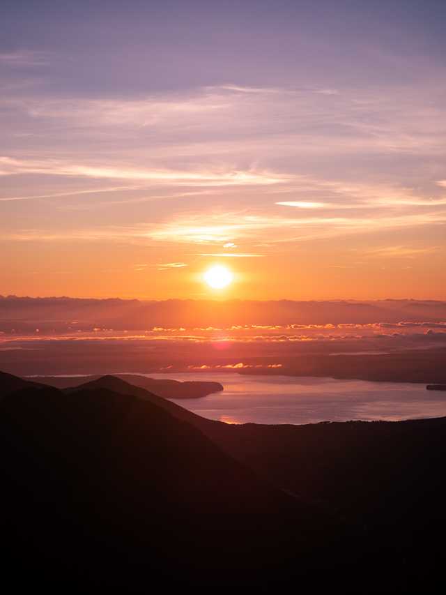 Layers of clouds are visible in the distance underneath a morning sunrise