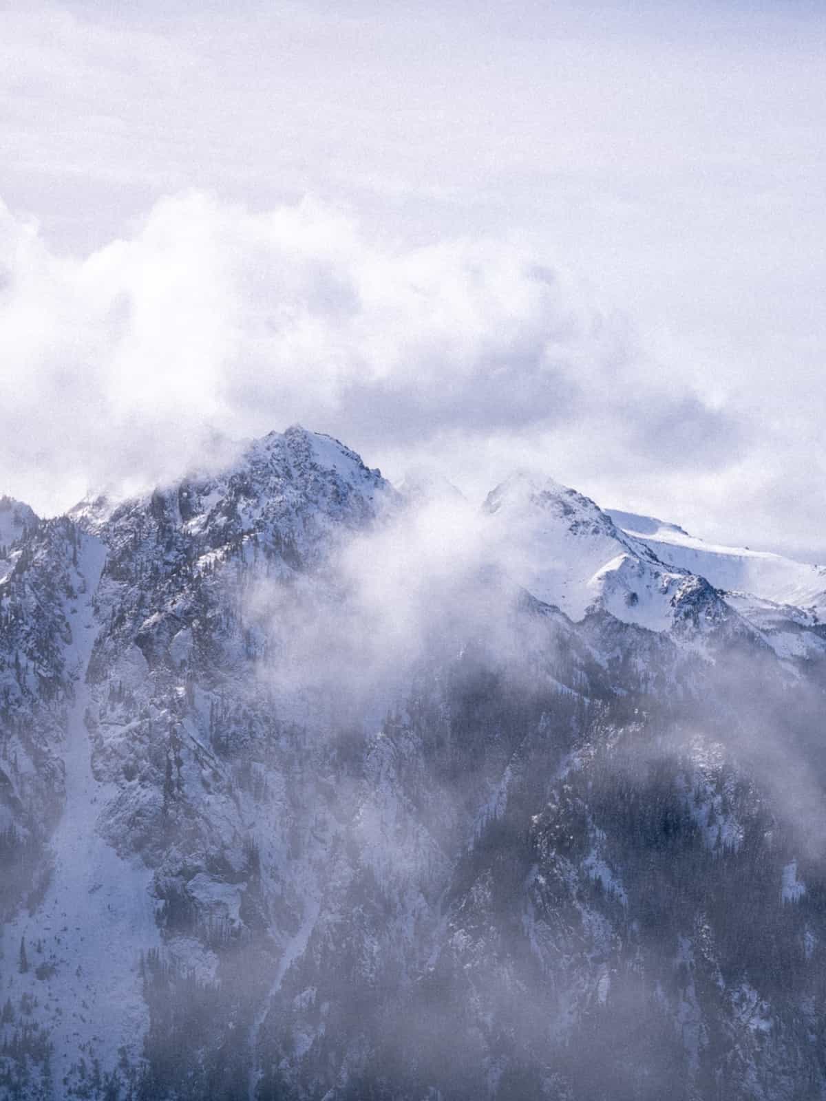 Ragged mountains partially obscured by clouds