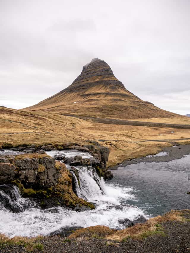 A singular tall mountain extends out of the ground, with waterfalls in the foreground