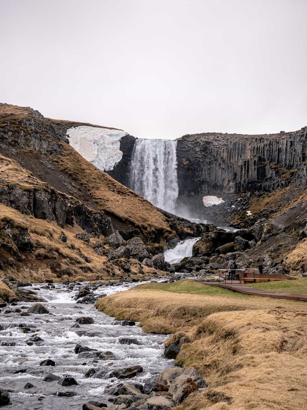 A large waterfall sits in a bowl, with a pathway walking up to a viewing platform nearby